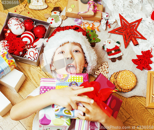 Image of little cute boy with Christmas gifts at home. close up emotional