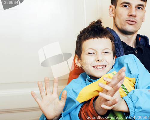 Image of young handsome father with his son fooling around at home, lifes