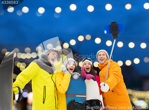 Image of happy friends with snowboards and smartphone