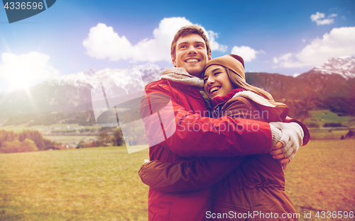 Image of happy couple hugging over alps mountains