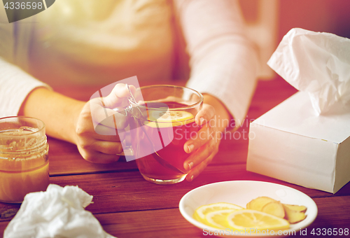 Image of close up of ill woman drinking tea with lemon