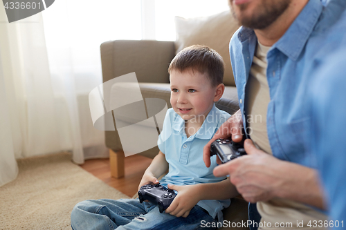 Image of father and son playing video game at home