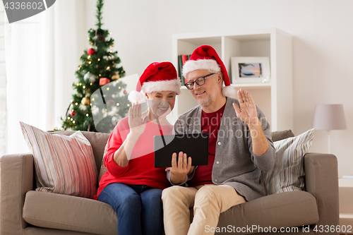 Image of happy senior couple with tablet pc at christmas