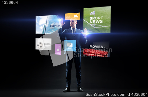 Image of businessman with applications on virtual screen
