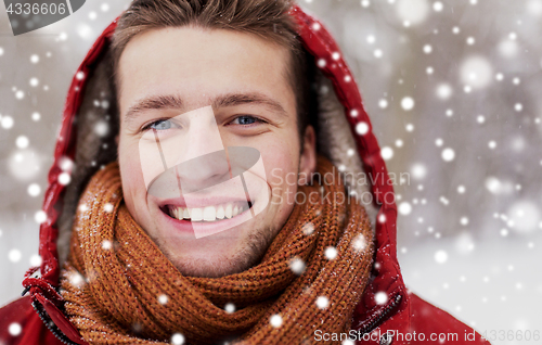 Image of close up of happy man in winter jacket with hood