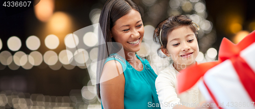 Image of happy mother and daughter with christmas gift