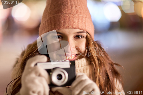 Image of close up of young woman with camera at christmas