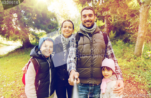 Image of family with backpacks taking selfie and hiking