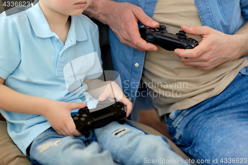 Image of close up of father and son playing video game