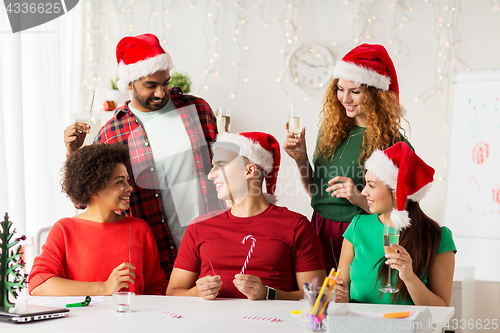 Image of happy team celebrating christmas at office party