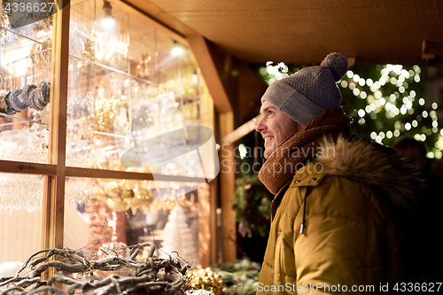 Image of happy man looking at christmas market shop window