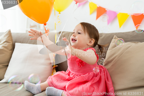 Image of happy baby girl on birthday party at home