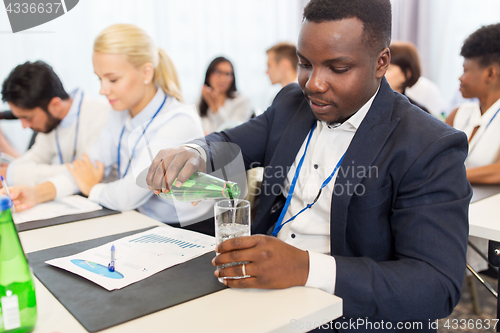 Image of businessman drinking water at business conference