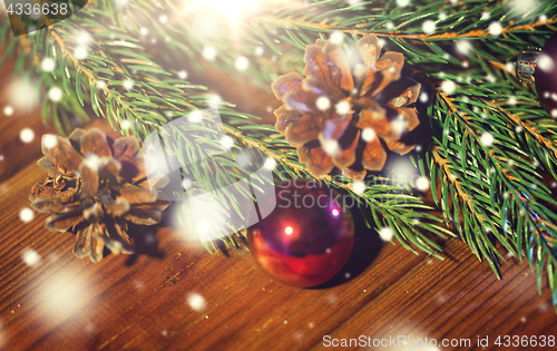 Image of fir branch with christmas ball and pinecones