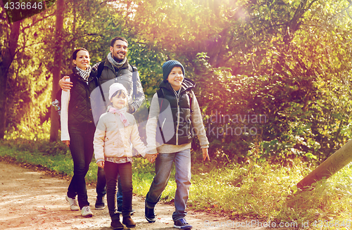 Image of happy family with backpacks hiking in woods