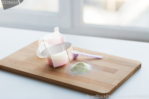 Image of infant formula, baby bottle and scoop on board