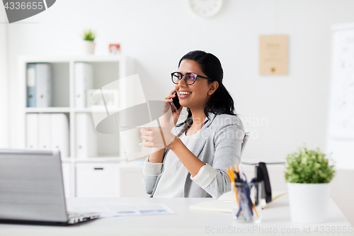 Image of businesswoman calling on smartphone at office