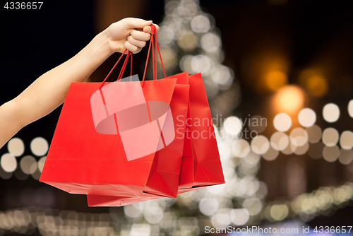 Image of close up of hand with shopping bags at christmas