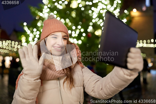 Image of woman with tablet pc at christmas tree outdoors