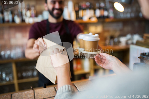 Image of man or bartender serving customer at coffee shop