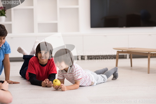 Image of boys having fun with an apple on the floor