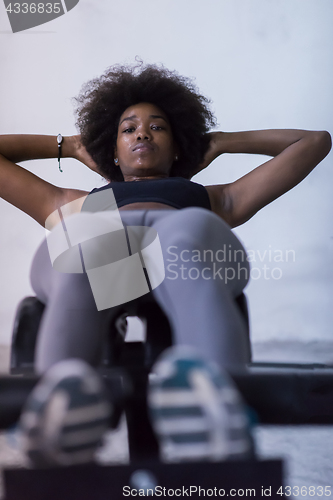 Image of black woman doing sit ups at the gym