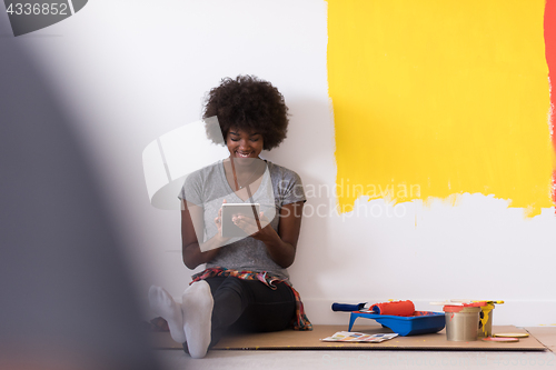 Image of back female painter sitting on floor