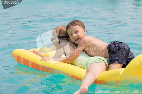 Image of Two happy children playing on the swimming pool at the day time.