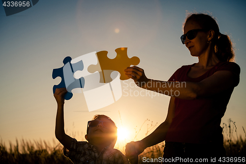 Image of Mother and son playing at the park at the sunset time.