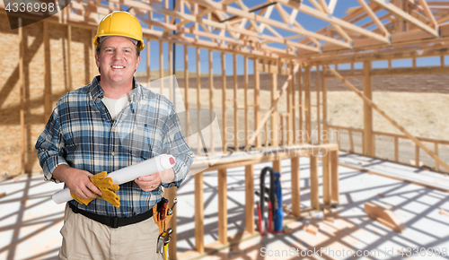 Image of Male Contractor With House Plans Wearing Hard Hat Inside New Hou