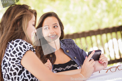 Image of Expressive Young Adult Girlfriends Using Their Smart Cell Phone 