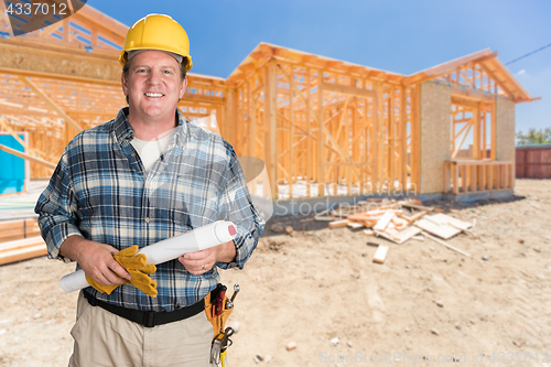 Image of Male Contractor With House Plans Wearing Hard Hat In Front of Ne