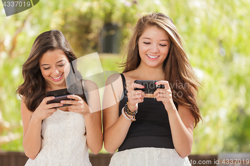 Image of Two Expressive Mixed Race Girlfriends Using Their Smart Cell Pho