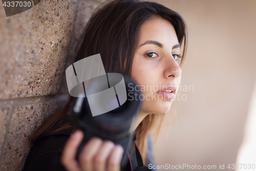 Image of Young Adult Ethnic Female Photographer Against Wall Holding Came