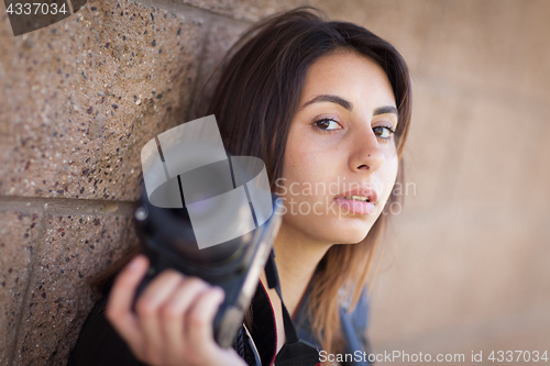 Image of Young Adult Ethnic Female Photographer Against Wall Holding Came