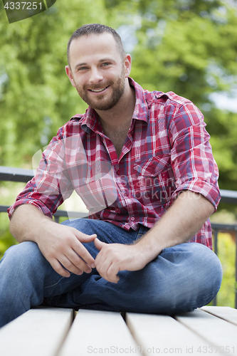 Image of a bearded man sitting outside