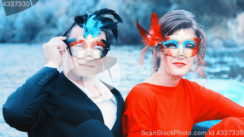 Image of Couple In Masquerade Masks At A Lake