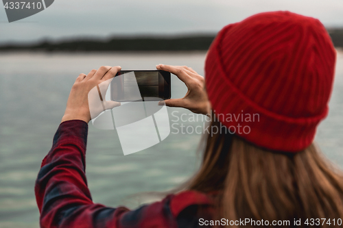 Image of Woman taking pictures with a cellphone