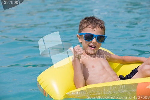 Image of happy child playing on the swimming pool at the day time.