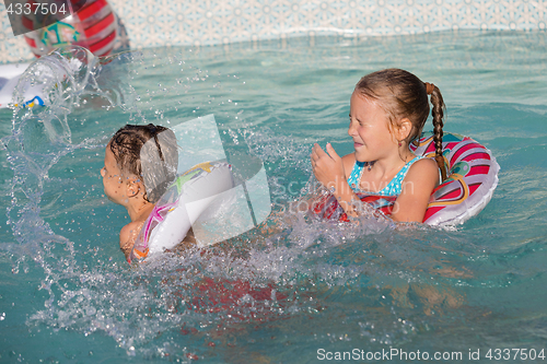 Image of Two happy children playing on the swimming pool at the day time.