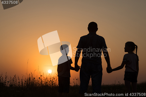 Image of Father and children playing in the park at the sunset time.