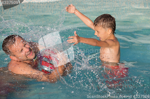 Image of Father and son  playing in the swimming pool at the day time.