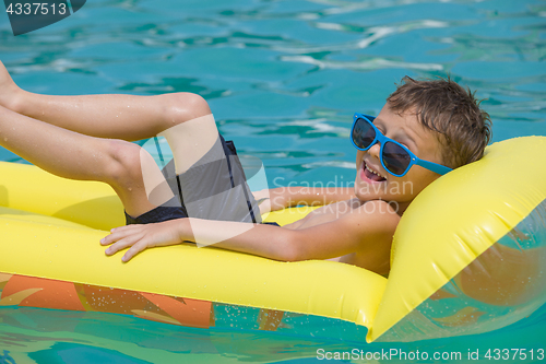 Image of happy child playing on the swimming pool at the day time.