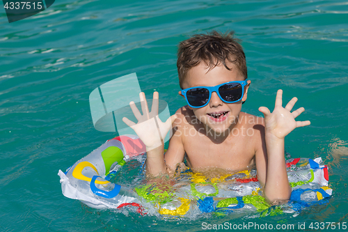 Image of happy child playing on the swimming pool at the day time.