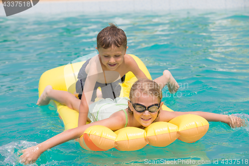 Image of Two happy children playing on the swimming pool at the day time.