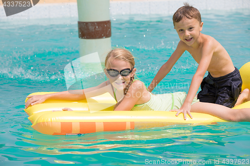 Image of Two happy children playing on the swimming pool at the day time.