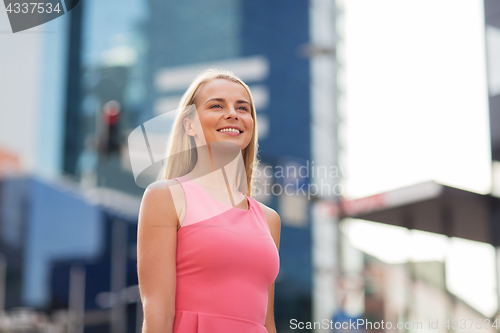 Image of happy smiling young woman on city street