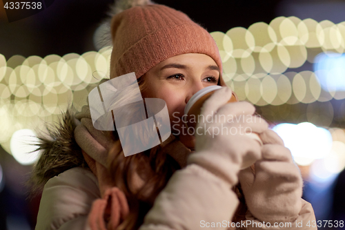 Image of happy woman with coffee over christmas lights