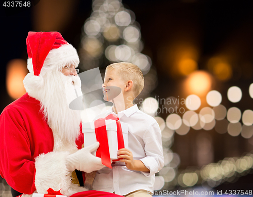 Image of santa claus and happy boy with christmas gift