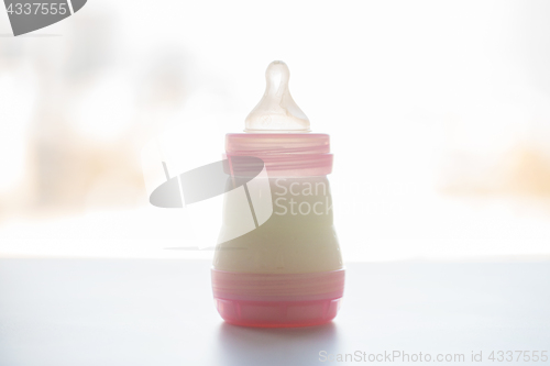 Image of infant milk formula in baby bottle on table